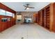 Spacious living room featuring wood paneling, brick fireplace, ceiling fan and built-in shelving at 634 N Riverside Dr, New Smyrna Beach, FL 32168