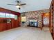 Living area featuring a brick fireplace, wood paneling, and tile flooring for a cozy and stylish interior at 634 N Riverside Dr, New Smyrna Beach, FL 32168