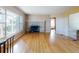 Living room with a stone fireplace, hardwood floors, and large windows letting in natural light at 634 N Riverside Dr, New Smyrna Beach, FL 32168