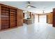 Open concept living room with ceiling fans, wood paneling, bar area, and access to the kitchen at 634 N Riverside Dr, New Smyrna Beach, FL 32168