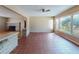 An open-concept living room featuring terracotta tile flooring, a fireplace, and large windows for natural light at 634 N Riverside Dr, New Smyrna Beach, FL 32168