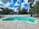 A beautiful private backyard pool with a concrete deck and a white concrete fence for privacy at 634 N Riverside Dr, New Smyrna Beach, FL 32168