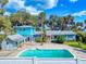 Beautiful pool area with turquoise water and an attached accessory building under a bright blue sky at 634 N Riverside Dr, New Smyrna Beach, FL 32168