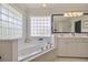 Spa-like bathroom with corner tub, double vanity and glass block windows at 6345 River Rd, New Smyrna Beach, FL 32169