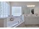 Bright bathroom boasts double vanity, a large soaking tub, and glass block windows at 6345 River Rd, New Smyrna Beach, FL 32169