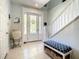 Entryway with tiled floor, white door, and blue bench at 6345 River Rd, New Smyrna Beach, FL 32169