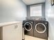 Bright laundry room with washer, dryer, and built-in storage at 6345 River Rd, New Smyrna Beach, FL 32169