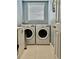 Well-lit laundry room featuring a side-by-side washer and dryer and neutral tile flooring at 6345 River Rd, New Smyrna Beach, FL 32169