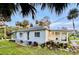 Quaint light blue home with a screened porch, and nicely landscaped yard at 69 E Bayshore Dr, Port Orange, FL 32127