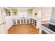 Bright kitchen with white cabinets, a farmhouse sink, and wood-look vinyl flooring at 69 E Bayshore Dr, Port Orange, FL 32127