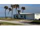 Charming beach home featuring turquoise shutters, a one-car garage, and swaying palm trees with ocean views at 8 Ocean Dr, Ormond Beach, FL 32176