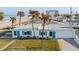 Charming beach home featuring turquoise shutters, a one-car garage, and swaying palm trees with ocean views at 8 Ocean Dr, Ormond Beach, FL 32176