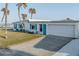 Coastal home with a white exterior, turquoise shutters, and an attached garage at 8 Ocean Dr, Ormond Beach, FL 32176