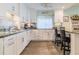 Bright kitchen featuring gray floors, white cabinets, stainless steel appliances, and eat-in bar seating at 8 Ocean Dr, Ormond Beach, FL 32176