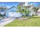 Light teal house with a white garage door, palm trees, and a spiral staircase at 806 E 21St Ave, New Smyrna Beach, FL 32169