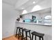 Kitchen breakfast bar with three black stools and a view into the living room at 806 E 21St Ave, New Smyrna Beach, FL 32169