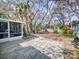 A lovely, sunny backyard with an opening to the enclosed porch, trees, and lots of vegetation at 808 E 19Th Ave, New Smyrna Beach, FL 32169