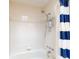 Bathtub with a shower head, tiled walls, and a blue and white striped shower curtain at 808 E 19Th Ave, New Smyrna Beach, FL 32169