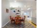 Open-concept dining area featuring wood floors, a colorful rug, and a view of the kitchen at 808 E 19Th Ave, New Smyrna Beach, FL 32169