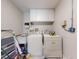 A functional laundry room featuring white appliances, overhead cabinets, and easy-to-clean flooring at 808 E 19Th Ave, New Smyrna Beach, FL 32169