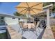 Outdoor deck includes an umbrella and patio table with seating beside the outdoor kitchen at 817 E 12Th Ave, New Smyrna Beach, FL 32169