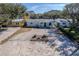 Charming home featuring a gravel driveway and inviting front porch with cheerful blue seating at 817 E 12Th Ave, New Smyrna Beach, FL 32169