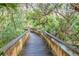 Wooden boardwalk path through lush green foliage at 91 Maura Ter, Ponce Inlet, FL 32127