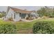 Backyard view of the home featuring a brick patio, sunroom, and manicured landscaping at 958 Beach Fern Ct, New Smyrna Beach, FL 32168