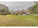 Lush backyard featuring a well-manicured lawn, mature trees, and a spacious patio at 958 Beach Fern Ct, New Smyrna Beach, FL 32168