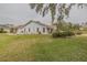 Well-maintained backyard showcasing lush green grass, manicured landscaping, and white siding at 958 Beach Fern Ct, New Smyrna Beach, FL 32168