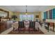 Formal dining room featuring a beautiful bay window, elegant chandelier, and classic wooden furniture at 958 Beach Fern Ct, New Smyrna Beach, FL 32168