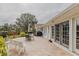 Expansive brick patio with outdoor seating, grill, and lush landscaping, perfect for entertaining at 958 Beach Fern Ct, New Smyrna Beach, FL 32168