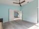 Open living room with modern ceiling fan, light-gray wood-look floors and open doorway to dining room at 108 Ocean Dr, New Smyrna Beach, FL 32169