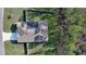 Aerial view of single-story home with solar panels, a fenced yard, and mature trees providing shade and privacy at 114 Sunset Point Dr, Ormond Beach, FL 32174