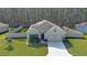 An elevated view of a well-maintained single-story home with solar panels, a two-car garage, and a fenced yard at 114 Sunset Point Dr, Ormond Beach, FL 32174