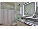 Bathroom featuring granite countertop, illuminated mirror, shower with curtain, and toilet at 114 Sunset Point Dr, Ormond Beach, FL 32174