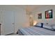 Bedroom featuring striped bedding, colorful wall art, and view to hallway at 114 Sunset Point Dr, Ormond Beach, FL 32174
