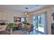 Bright dining area with a glass table, slider to the backyard, and modern light fixture at 114 Sunset Point Dr, Ormond Beach, FL 32174