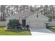 Charming single-story home with a well-manicured lawn, attached garage, and an American flag at 114 Sunset Point Dr, Ormond Beach, FL 32174