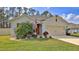 Charming single-story home with a manicured lawn, mature landscaping, and an attached two-car garage at 114 Sunset Point Dr, Ormond Beach, FL 32174