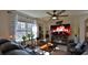 Cozy living room featuring a ceiling fan, decorative fireplace, and large window with natural light at 114 Sunset Point Dr, Ormond Beach, FL 32174