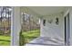 A covered outdoor patio with a view of the lush, green backyard and decorative lizard wall hangings at 114 Sunset Point Dr, Ormond Beach, FL 32174