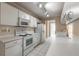 Updated kitchen featuring white appliances and cabinetry, complemented by a white tiled floor and countertops at 128 Black Crow Cir # 4070, Daytona Beach, FL 32119