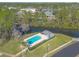 Aerial shot of a pool with clear water and a pool house, surrounded by lush trees and landscaping at 128 Black Crow Cir # 4070, Daytona Beach, FL 32119