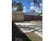 Backyard featuring a mixed wood fence, extensive concrete driveway area, and natural landscaping at 128 Orange Ave, Edgewater, FL 32132