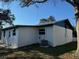 Backyard with a well-kept yard, freshly painted house, and a functional air conditioning unit at 128 Orange Ave, Edgewater, FL 32132