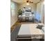 This is a cozy bedroom and office space featuring wood floors, a ceiling fan and a sleek white modern desk at 128 Orange Ave, Edgewater, FL 32132