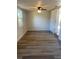 Bright bedroom with sleek ceiling fan, a large window, and stylish, light-colored wood floor at 128 Orange Ave, Edgewater, FL 32132