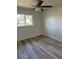 Inviting bedroom featuring modern ceiling fan and window providing natural light, complemented by stylish wood flooring at 128 Orange Ave, Edgewater, FL 32132