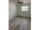 Cozy bedroom featuring wood-look flooring, a ceiling fan, and a window providing ample natural light at 128 Orange Ave, Edgewater, FL 32132